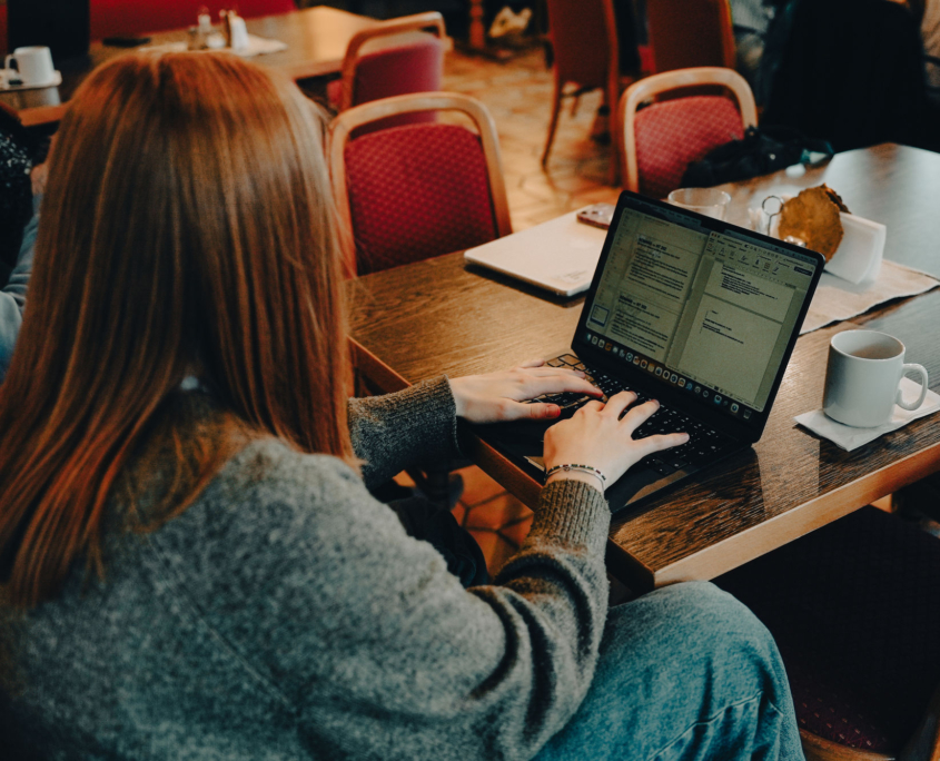 A female student studying and taking notes on her laptop at the European Theological Seminary.