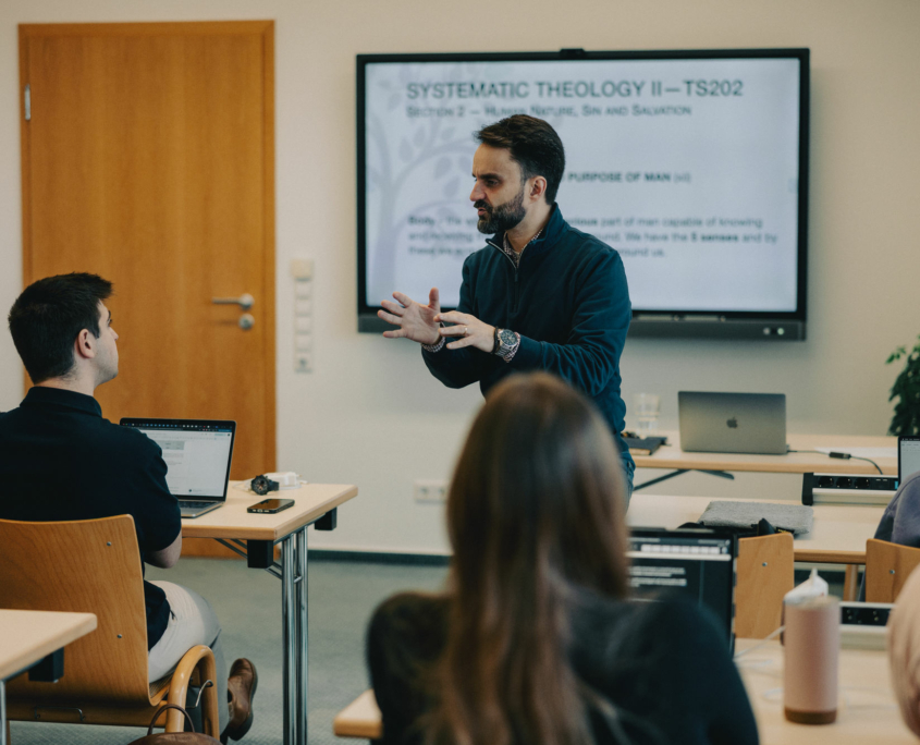 The President of the European Theological Seminary is explaining something to a student